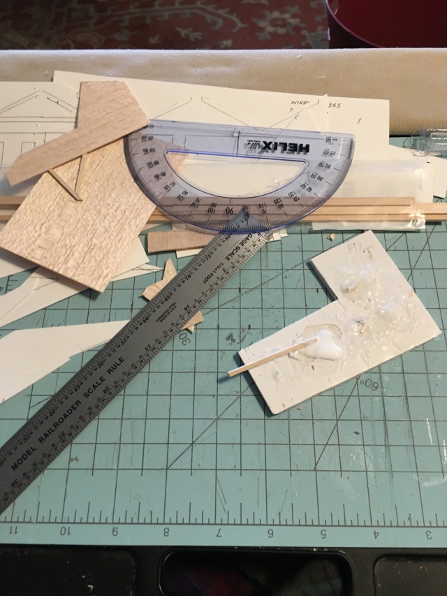 Lap desk, cutting board, protractor, scale ruler, and balsa pieces.